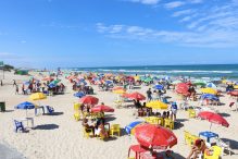 crowded public beach with umbrellas